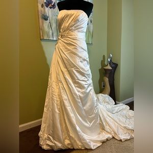 Satin A-Line Wedding Gown with flower appliques, sleeveless bodice and ruching.